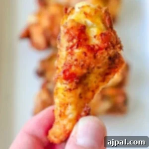 a hand holding a chicken wing seasoned with cajun seasoning