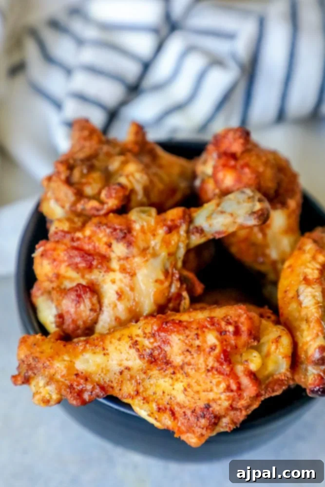 Spicy Cajun Baked Chicken Wings 5 Crispy seasoned baked chicken wings in a bowl on a table, highlighting the delicious dry rub.