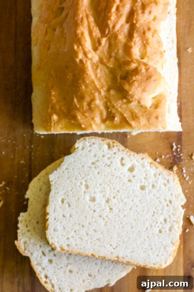 Artfully sliced keto bread resting on a rustic wooden cutting board, showcasing its authentic texture and readiness to be toasted and topped.