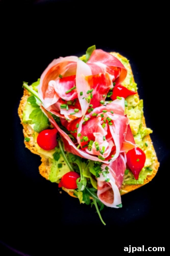 A close-up of an Easy Keto Avocado Toast, beautifully arranged with avocado spread, crispy prosciutto, and fresh herbs, ready to be enjoyed as a wholesome keto meal.