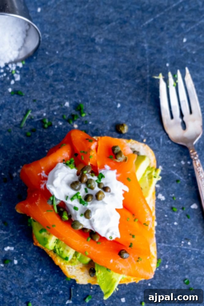 A close-up view of a delicious keto lox avocado toast, featuring smoked salmon, capers, and sour cream.