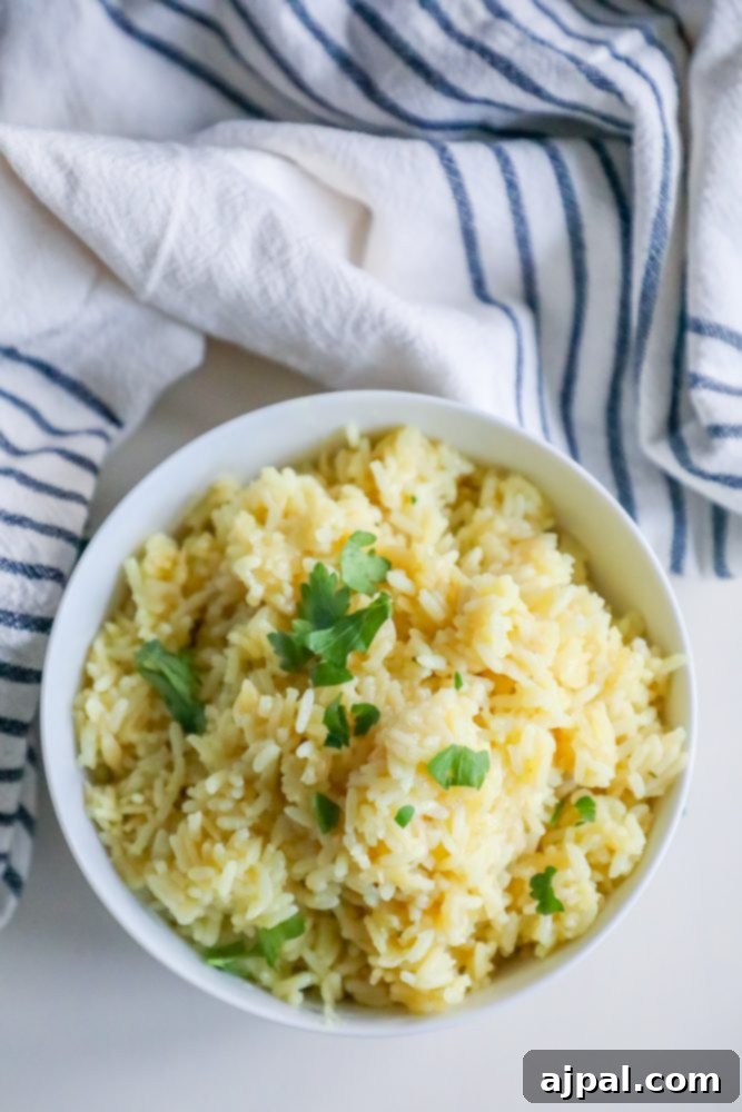 rice pilaf with parsley on it in a white bowl with towel around it