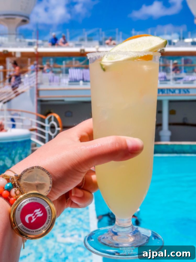 A refreshing Pina Colada held in front of a sparkling cruise ship pool, with the vast ocean extending into the horizon, symbolizing relaxation and luxury.