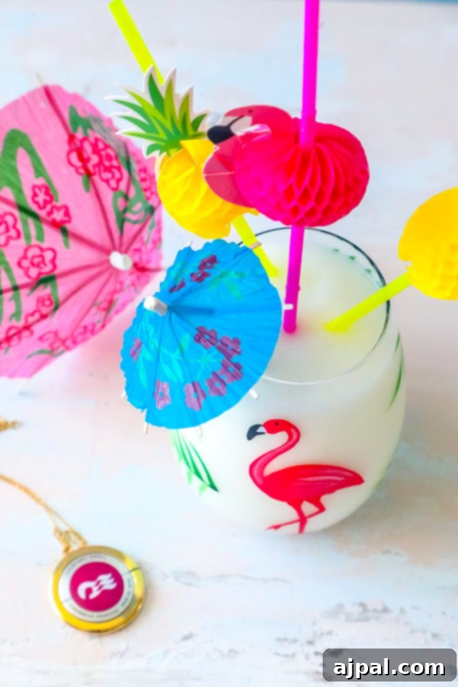 A perfectly blended Pina Colada, adorned with a whimsical flamingo garnish and a vibrant necklace, embodying the playful spirit of a tropical getaway.