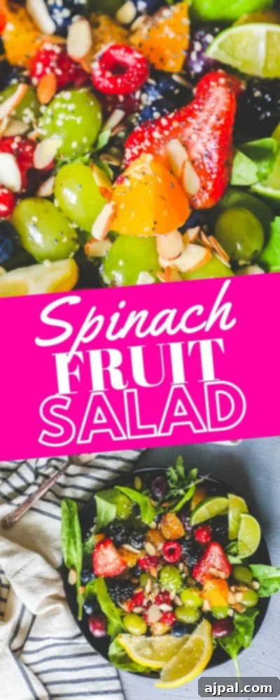 A plate of freshly prepared spinach fruit salad with citrus poppyseed dressing, showcasing the colorful fruits and greens.
