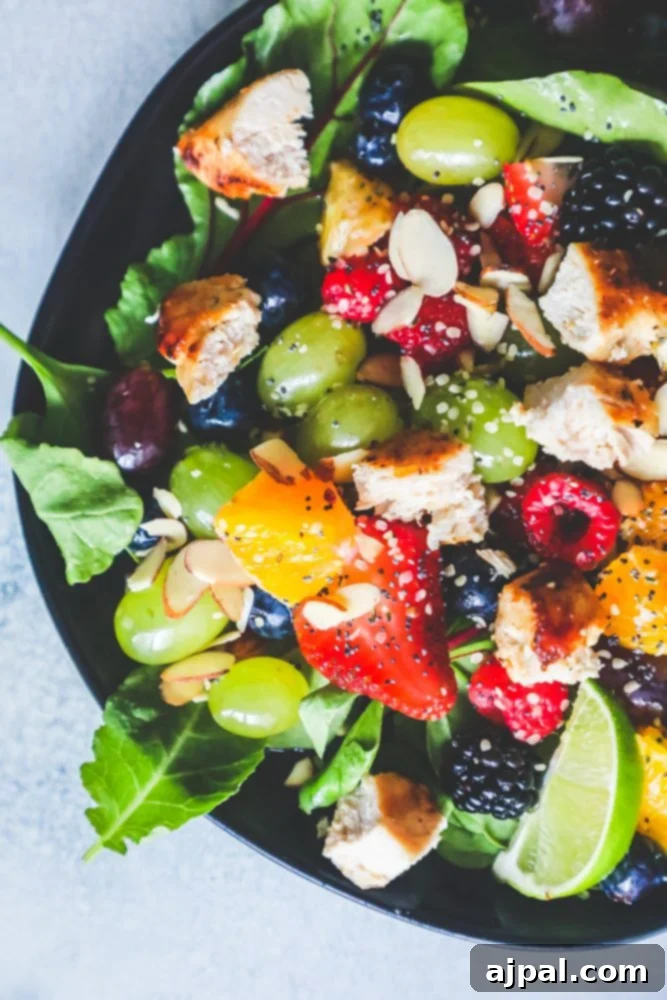 A beautifully presented bowl of chicken fruit salad with almonds, highlighting the fresh ingredients and the tender chicken pieces, ready to be dressed.