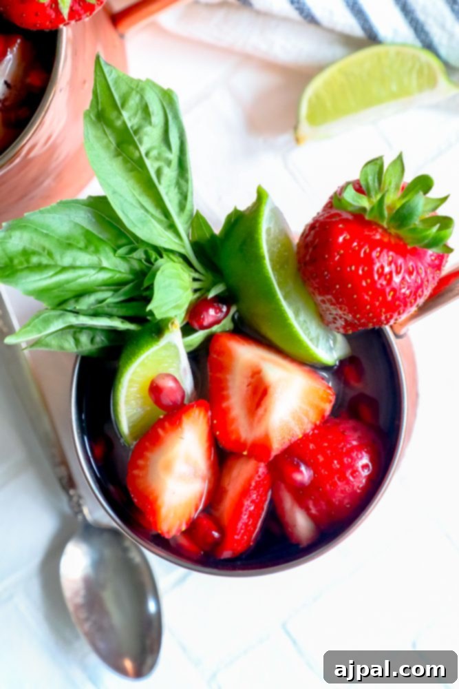 Fresh Strawberry Basil Moscow Mule 6 Picture of a Strawberry Basil Moscow Mule in a copper cup with strawberries, mint, basil, and ice, ready to be enjoyed.