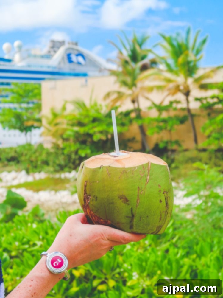 A woman holding a fresh coconut, showcasing her Ocean Medallion bracelet on the Caribbean Princess – a symbol of a carefree vacation.