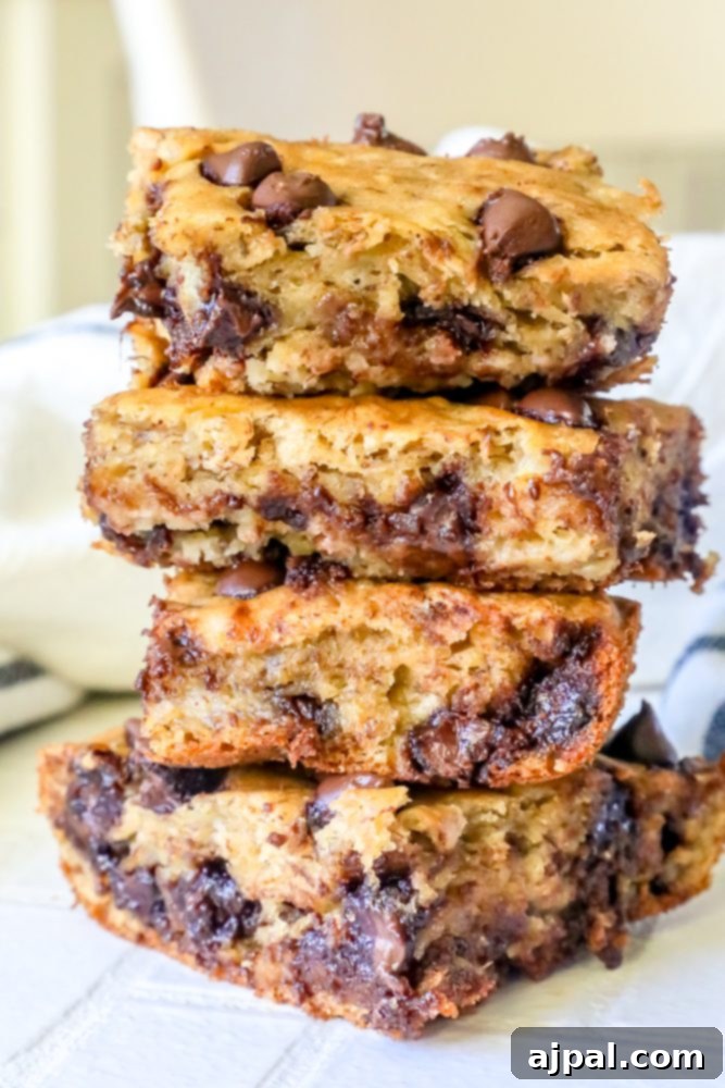 A stack of four moist banana chocolate chip bars, showing their delicious layers and generous chocolate chips.
