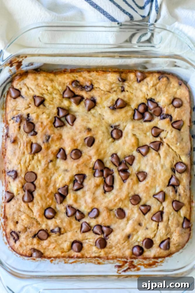 A close-up of a stack of four perfectly square banana chocolate chip bars, showcasing their even bake and delicious texture.
