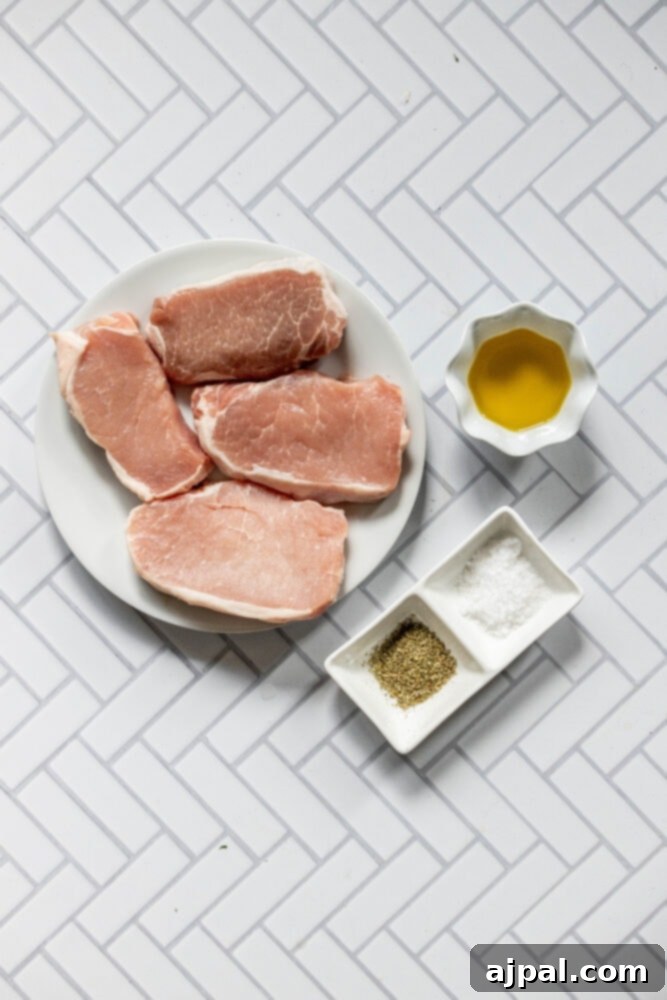 Perfectly Pan Fried Thin Pork Chops 5 A selection of raw, thin-cut pork chops on a plate, surrounded by bottles of olive oil and various spices, ready for marination.