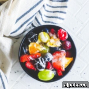 A lemon poppyseed glazed fruit salad sitting on a table with a towel.