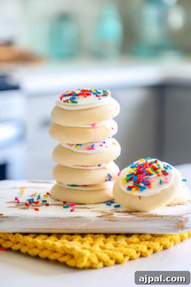 Simple Lofthouse Style Frosted Sugar Cookies 9 picture of 7 cookies stacked on a cutting board in a kitchen