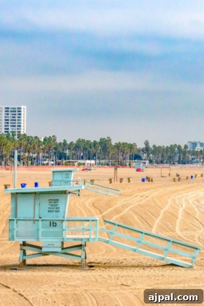 Golden State Wanderlust 12 A vibrant lifeguard tower stands on a sandy beach in Santa Monica, California, under a bright sky, inviting travelers on a coastal road trip.