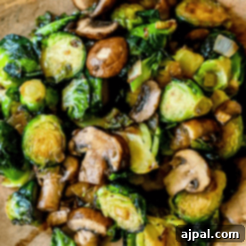 Discover the best Brussels sprouts and mushrooms recipe: perfectly sautéed with onions on a wooden surface.