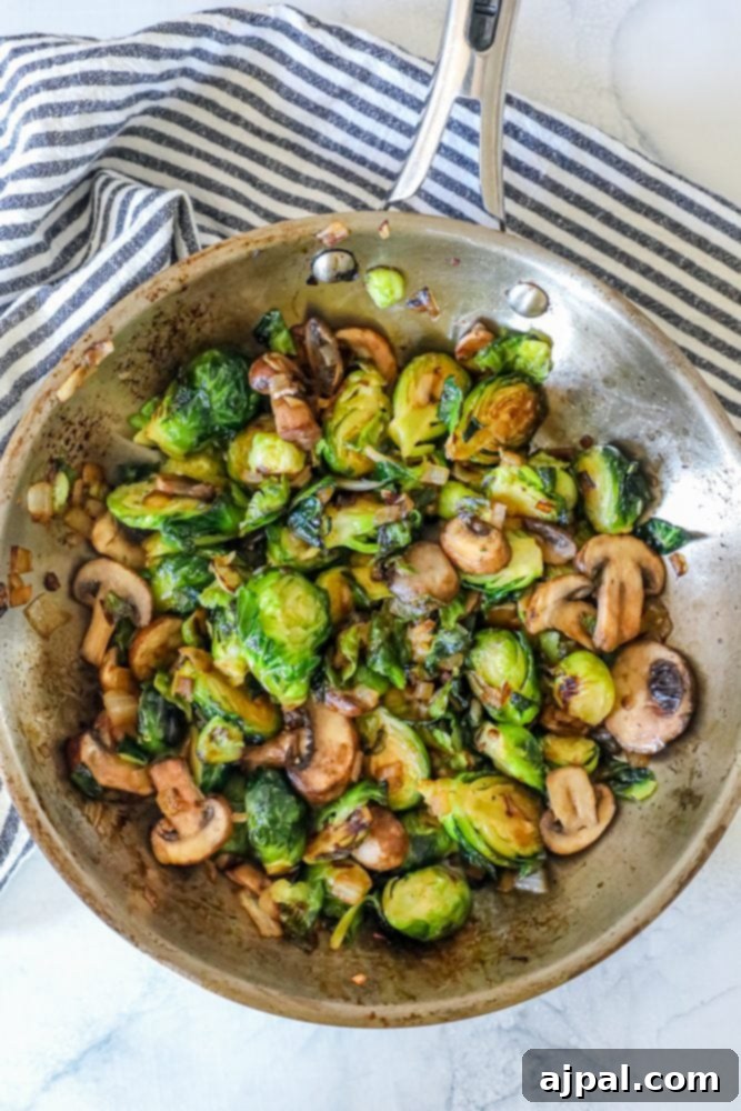 roasted Brussel sprouts and mushrooms in a stainless steel pan