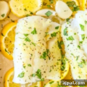 picture of baked cod in a dish with lemon and garlic cloves