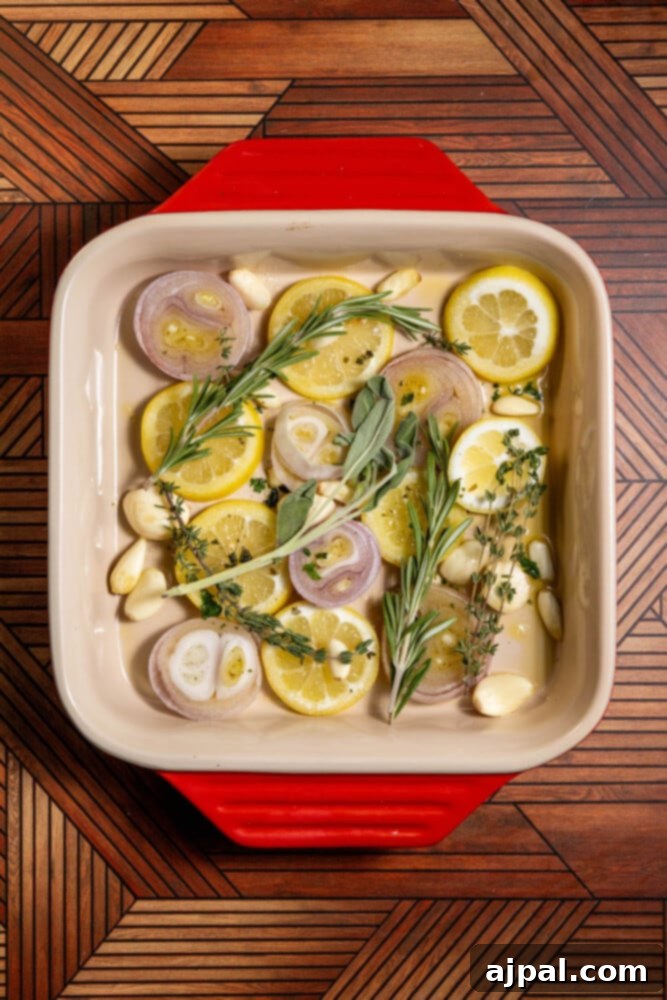 The Ultimate Cornish Game Hen Recipe 5 slices of lemon, slices of shallots, garlic cloves, and sprigs of herbs in a baking dish