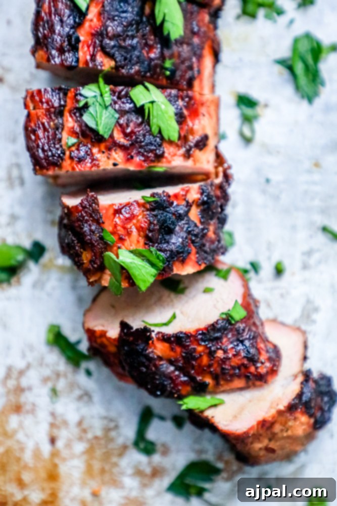 The Ultimate Grilled Pork Tenderloin 7 Grilled pork tenderloin garnished with herbs.