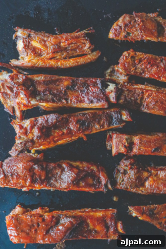 Perfectly cooked slow cooker BBQ ribs glistening with barbecue sauce.