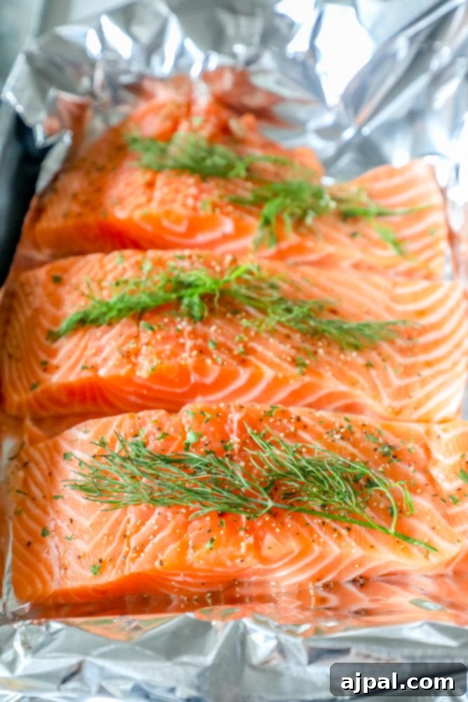 salmon in tin foil with spices and fresh dill on it