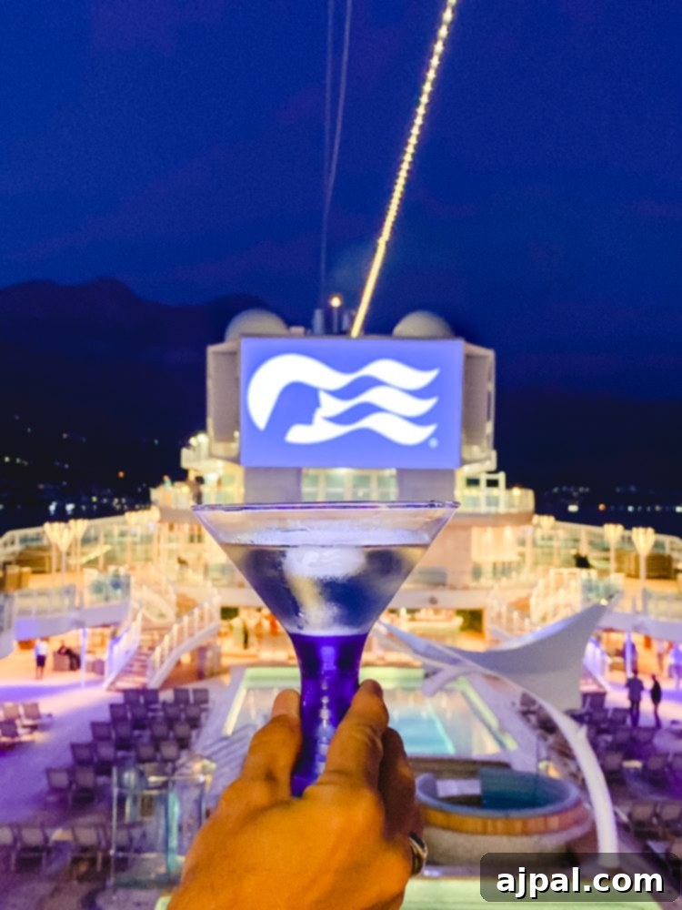 Sky Princess's Stellar Bar Hop 3 A person joyfully cheers with a martini glass, captured during the Ultimate Sky Princess Cruise Ship bar crawl, symbolizing the lively atmosphere and exquisite drinks available.
