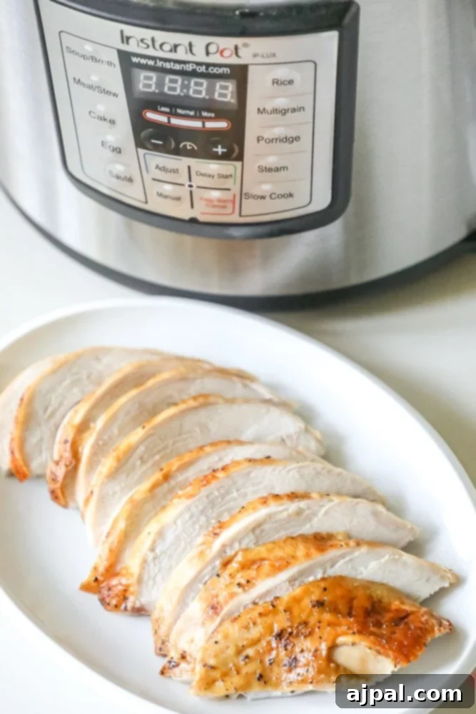 Perfect Instant Pot Turkey Breast 2 Picture of perfectly sliced, golden-brown turkey breast on a white plate, with an Instant Pot blurred in the background, ready to be served for an easy dinner.
