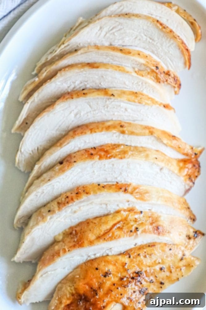 Perfect Instant Pot Turkey Breast 4 A beautiful platter of thinly sliced, succulent roasted turkey breast, garnished with fresh herbs, ready to be served.