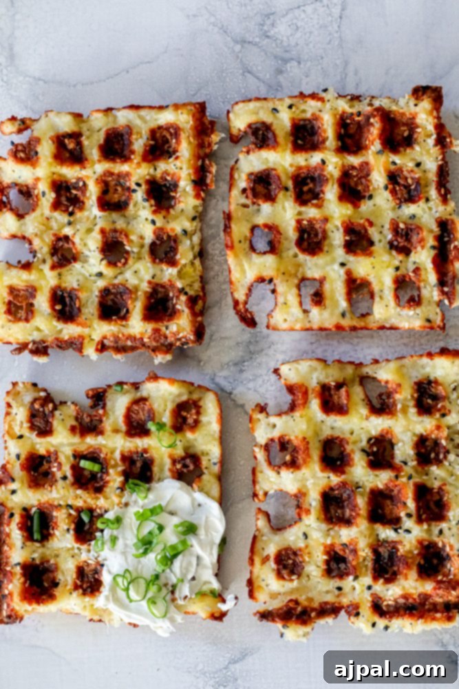 Ultimate Keto Chaffles 3 A plate featuring four golden-brown keto everything chaffles, one topped generously with sour cream and chopped green onions