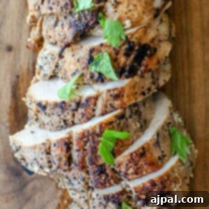 Grilled chicken slice on a cutting board.