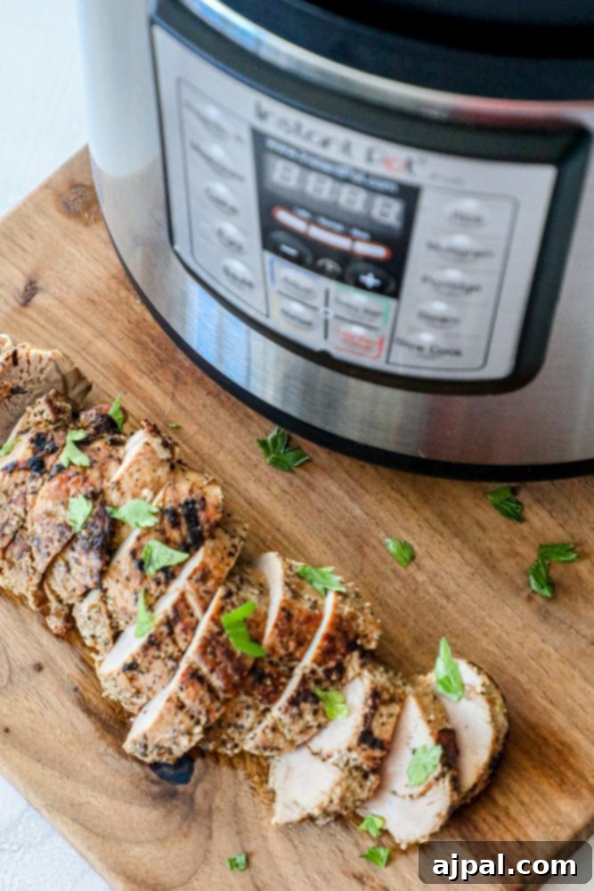 Ultimate Pressure Cooker Pork Tenderloin 3 Close-up picture of perfectly cooked pork tenderloin slices on a cutting board, ready to serve.