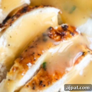 A plate of chicken with delicious gravy and creamy mashed potatoes.