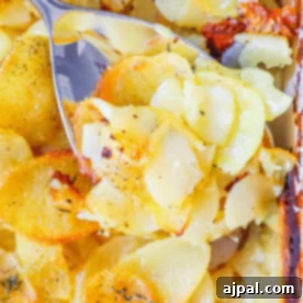Close-up of a serving spoon scooping sliced, baked potatoes with a golden, crispy top from a casserole dish—perfectly showcasing this cheesy scalloped potatoes recipe.