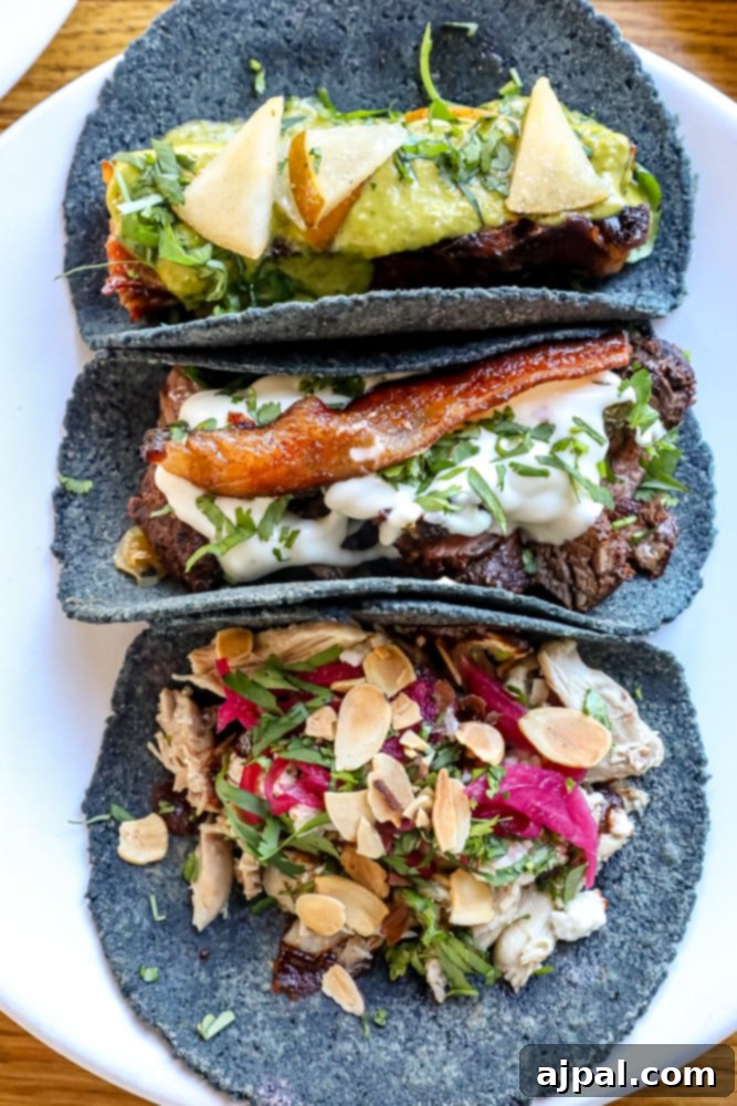 SoCal Taco Trail: An Epic Road Trip 2 Three tacos on a wooden table, featuring fresh ingredients and vibrant colors, ready to be enjoyed on a Southern California food adventure.