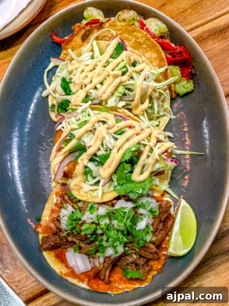SoCal Taco Trail: An Epic Road Trip 4 Three perfectly crafted tacos presented on a sleek plate, showcasing colorful fillings and fresh garnishes, a highlight of a Southern California foodie road trip.