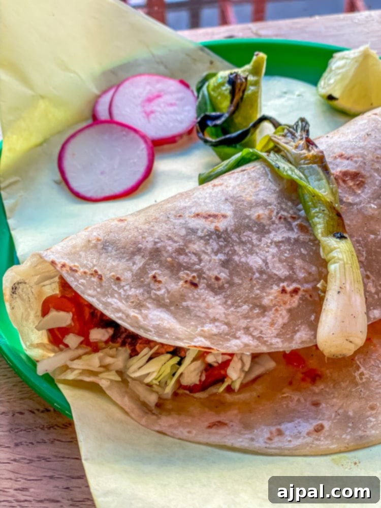 SoCal Taco Trail: An Epic Road Trip 7 A vibrant green plate showcasing a delectable beef caramelo burrito, bursting with rich flavors and fresh ingredients, a must-try on a California taco road trip.