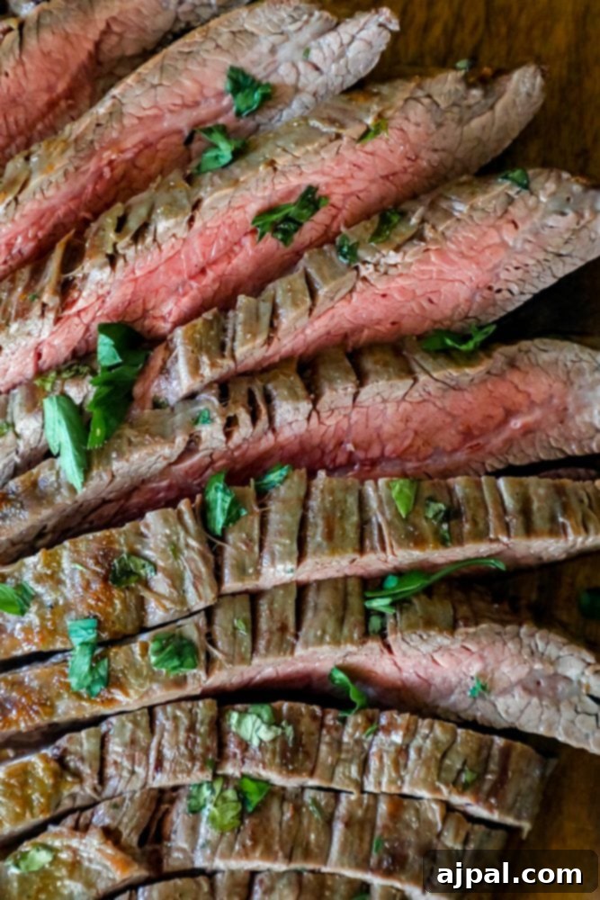 Perfectly Tender Oven Flank Steak 6 Broiled flank steak on a cutting board.