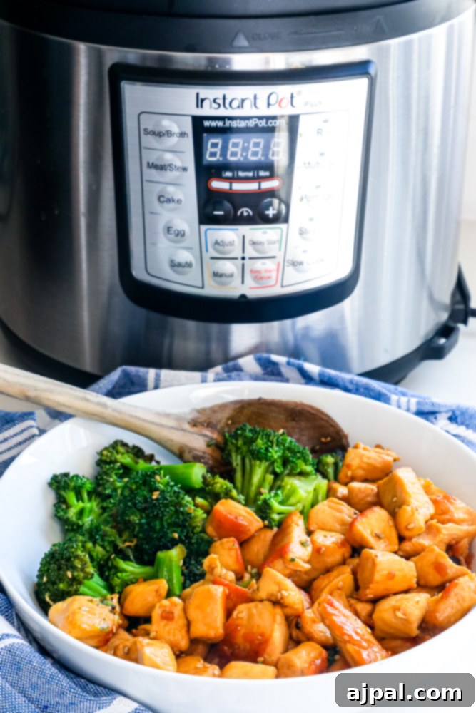 A vibrant bowl of Instant Pot Chicken Teriyaki with steamed broccoli, garnished with sesame seeds and green onions, ready to serve.