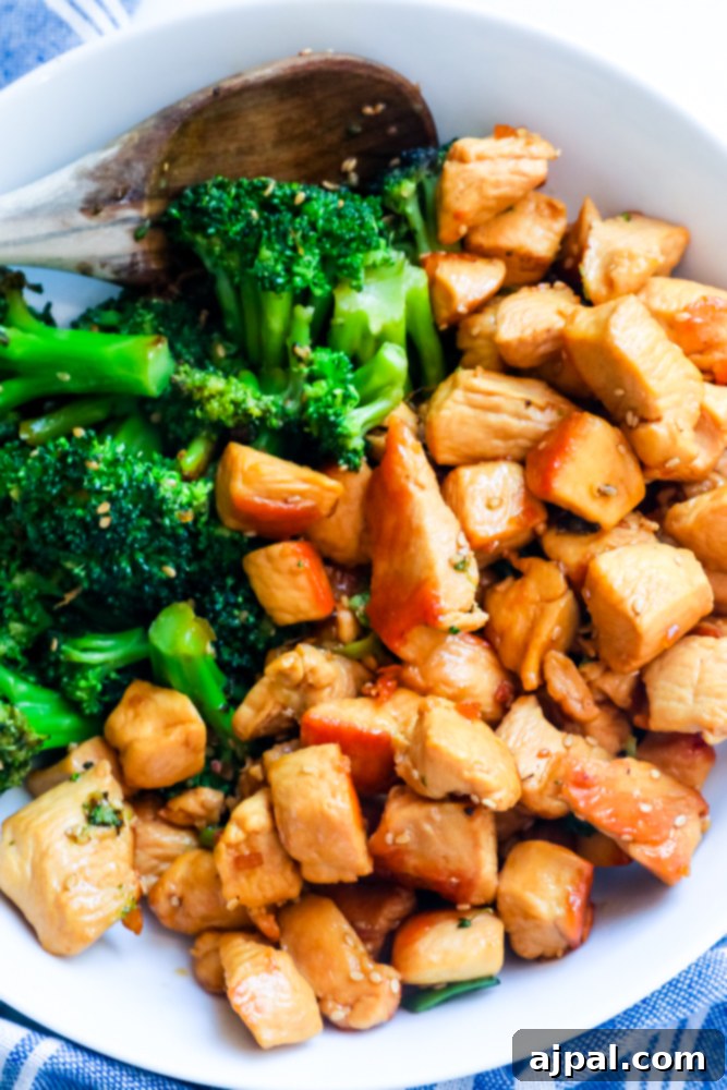 A white bowl filled with Instant Pot Chicken Teriyaki, featuring tender chicken pieces and green broccoli florets.