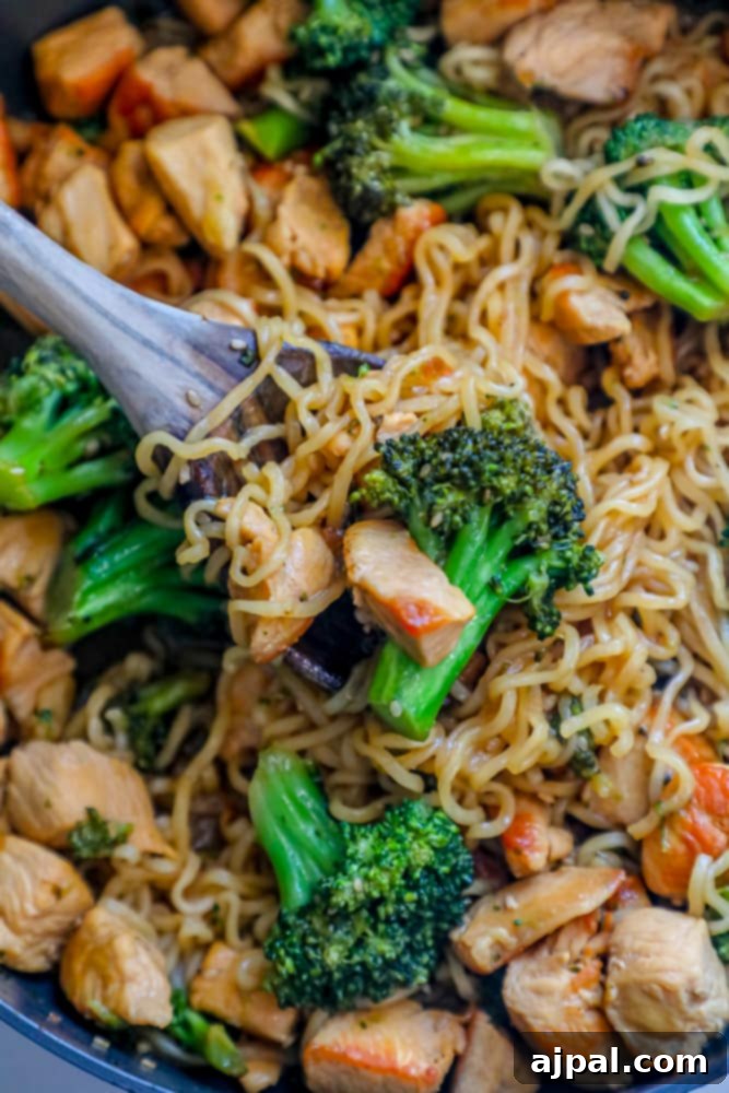 Homemade Teriyaki Chicken Noodles 4 Close-up of chicken teriyaki noodles with broccoli in a skillet, showcasing the rich sauce and tender ingredients