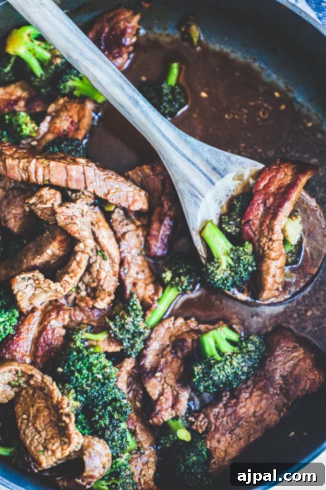 strips of beef, broccoli in a rich sauce. Some meat on a spoon.