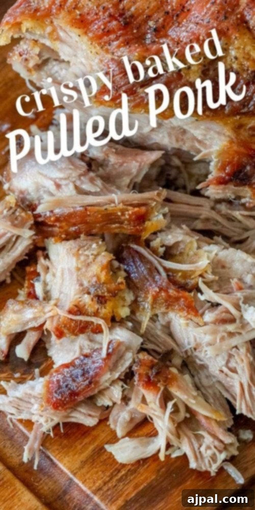 Ultimate Crispy Baked Pork Shoulder 8 Pulled pork with crunchy skin shredded on a cutting board, garnished and ready.