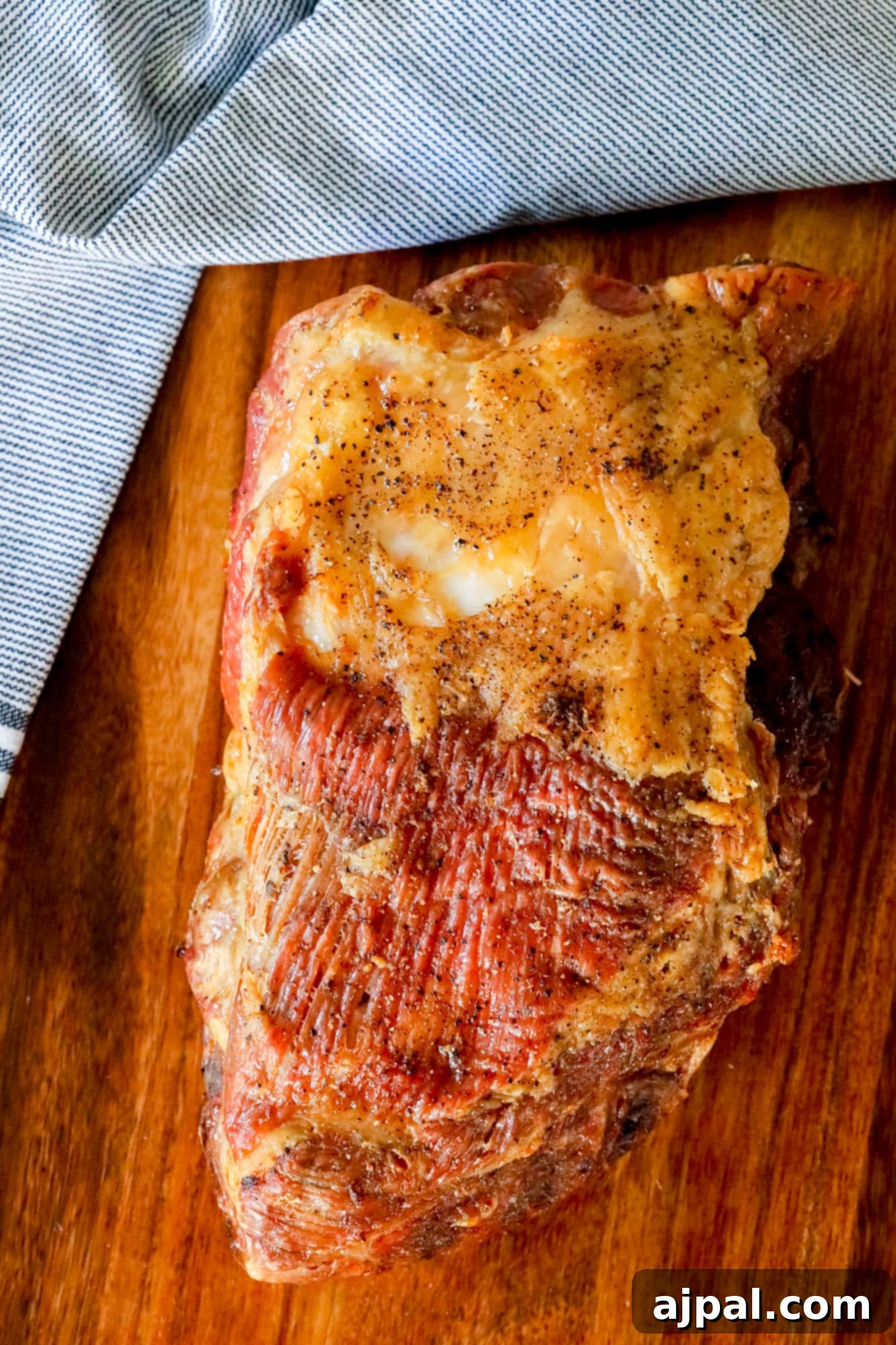 Ultimate Crispy Baked Pork Shoulder 6 Picture of shredded pulled pork on a cutting board, ready for the crisping stage.