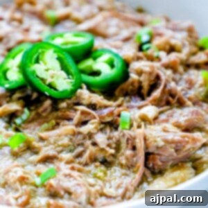 Zesty Green Chile Pork Carnitas 12 A bowl of Instant Pot pulled pork with jalapenos, topped with green chile.