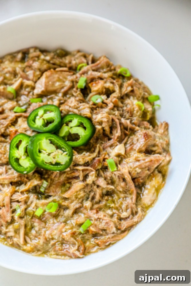 Zesty Green Chile Pork Carnitas 6 A bowl of flavorful Instant Pot pulled pork, garnished with vibrant jalapeños, ready to be enjoyed.