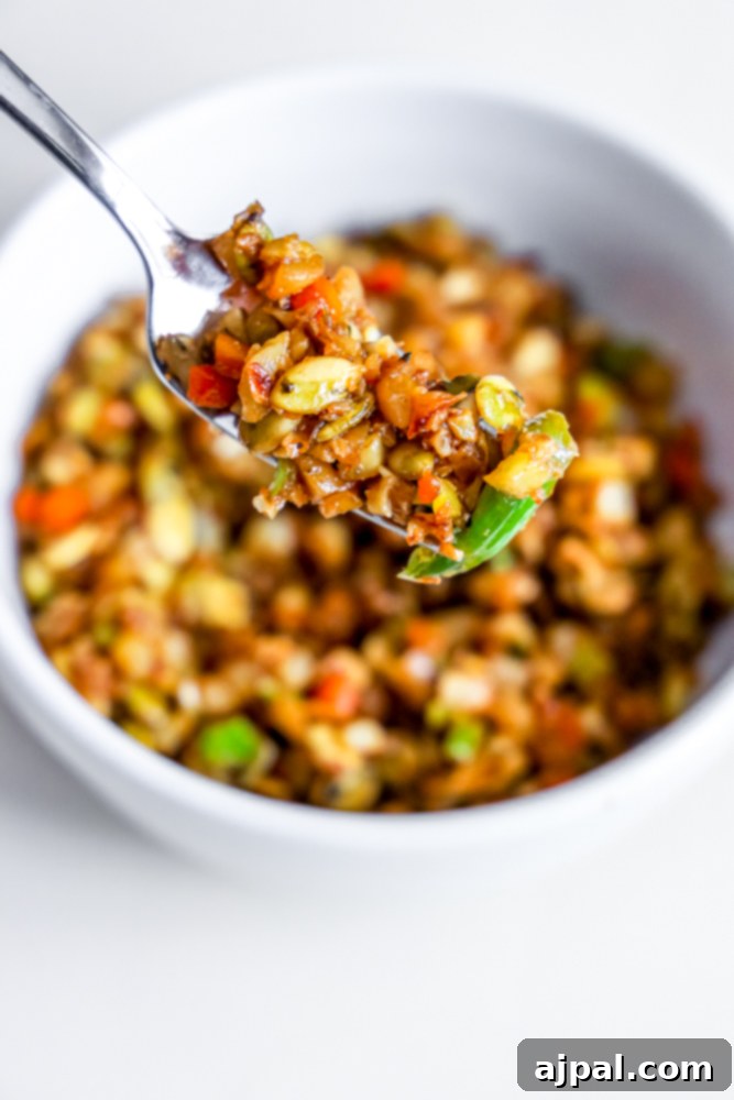 fried rice with onion, cabbage, and nuts on a fork