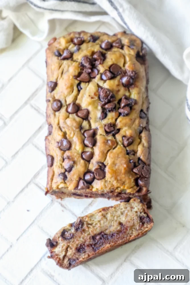 Picture of a delicious chocolate chip banana bread loaf with a slice cut, showing the moist interior
