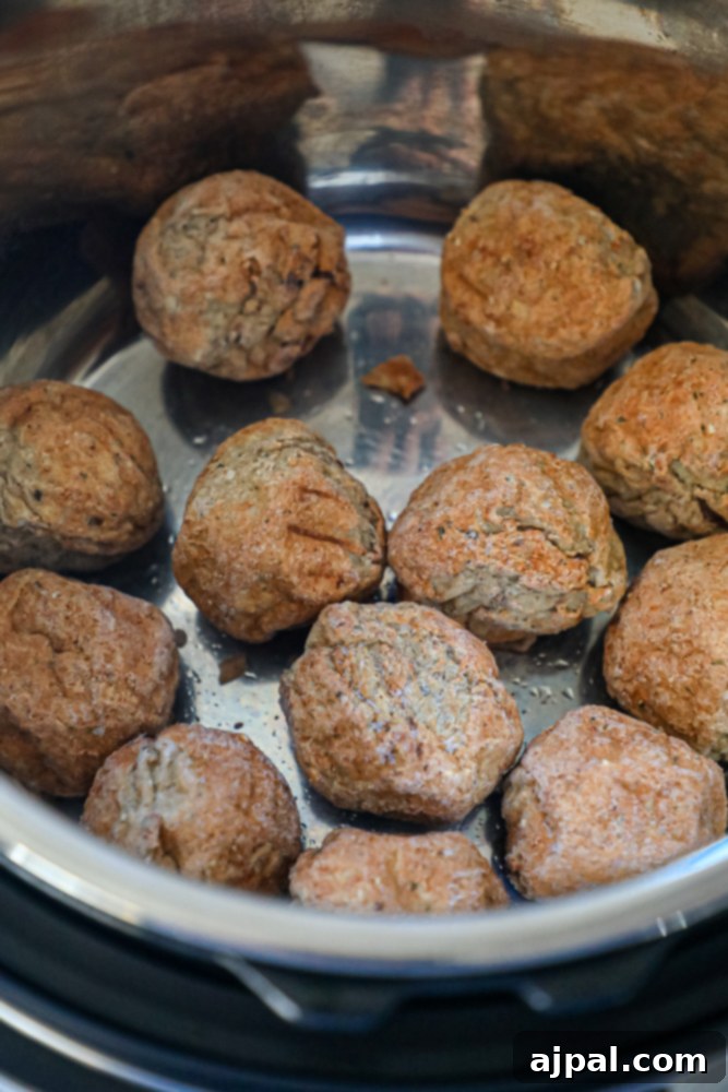 picture of frozen meatballs layered in Instant Pot before adding other ingredients