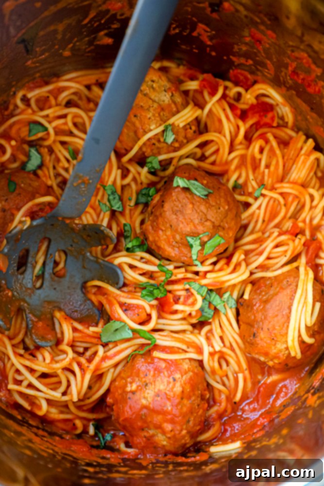 Picture of spaghetti and meatballs layered in instant pot before cooking