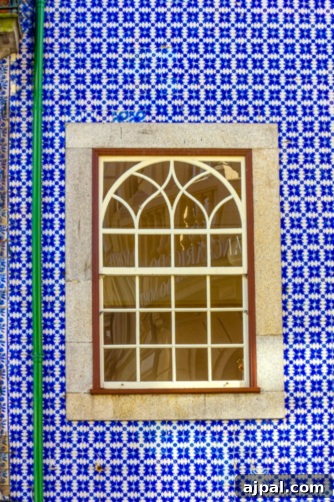Crafting the Perfect Port and Tonic 18 An exquisitely tiled wall in Porto, Portugal, featuring a window adorned with intricate blue and white patterns, a hallmark of Portuguese design.